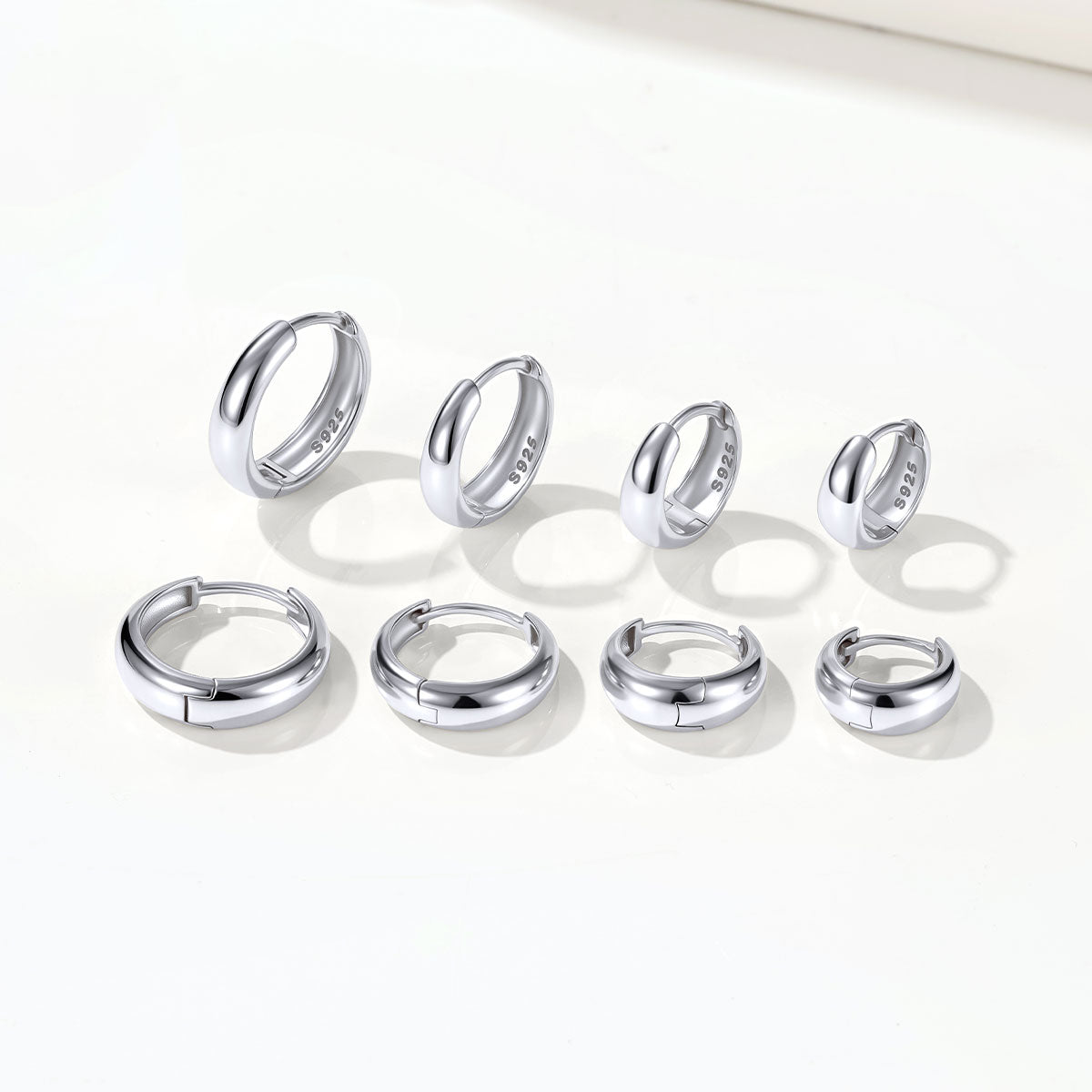 Set of silver chunky hoop earrings on a white background