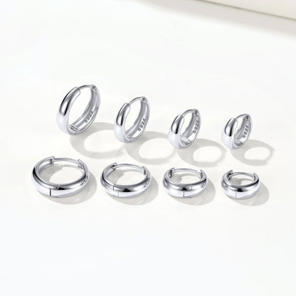 Set of silver chunky hoop earrings on a white background