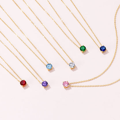 Seven Solitaire Birthstone Necklace on a pink background