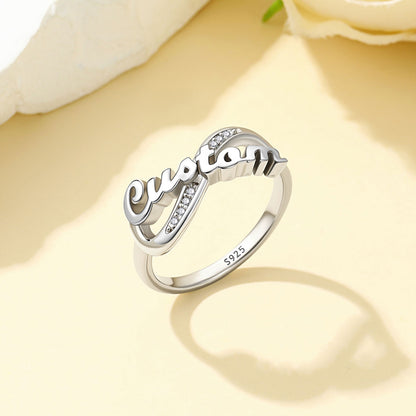 Silver Custom Name Infinity Promise Ring With Cubic Zirconia ion a light yellow background