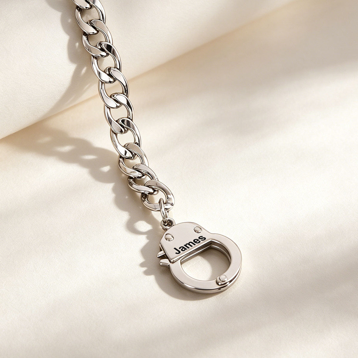 Silver chain bracelet with a lock charm on a light background