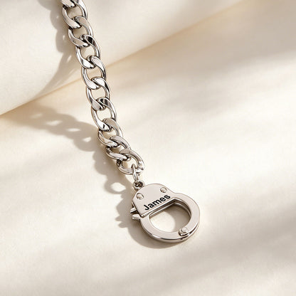 Silver chain bracelet with a lock charm on a light background