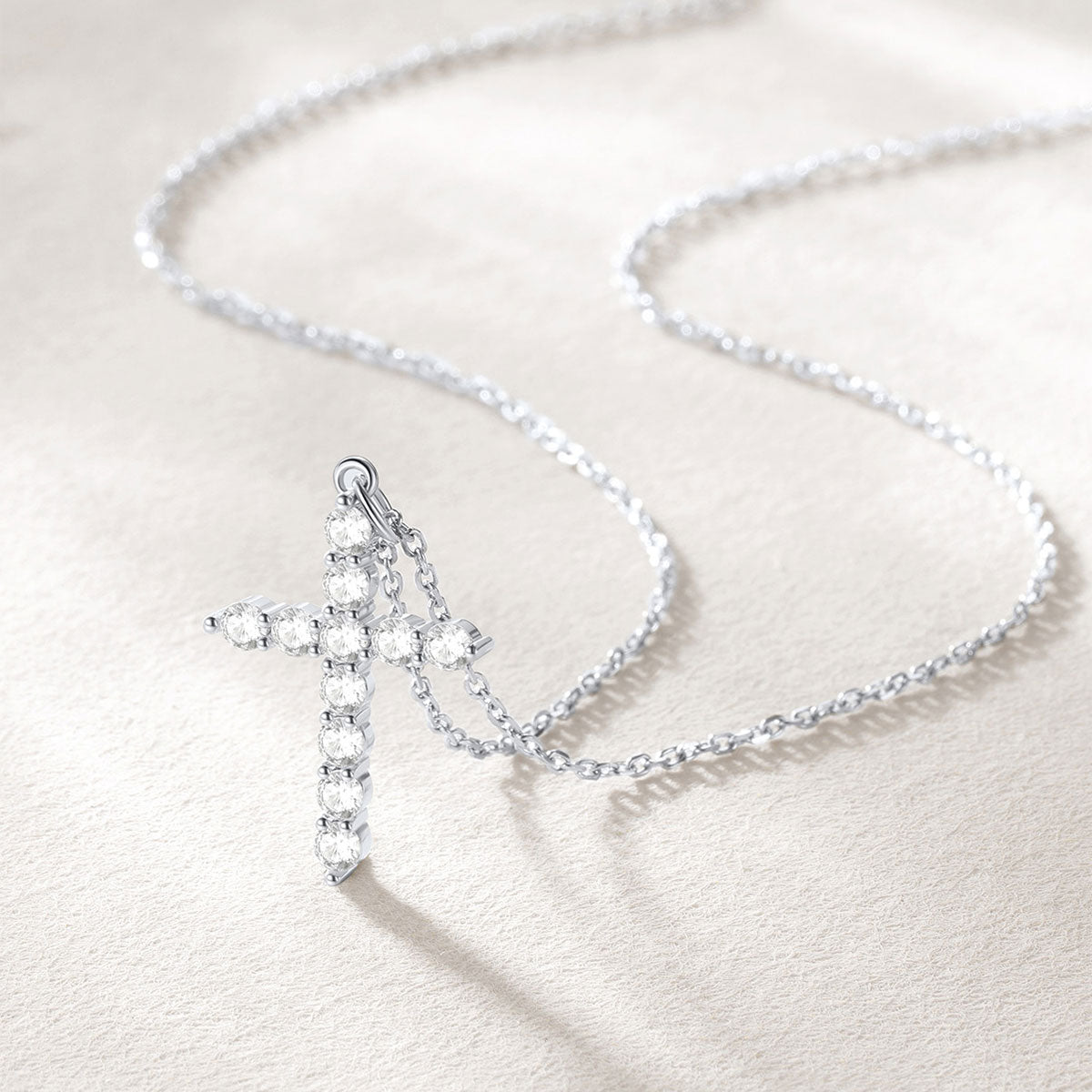 Silver cross necklace on a light background