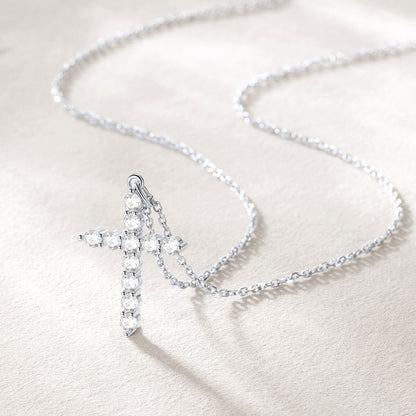 Silver cross necklace on a light background