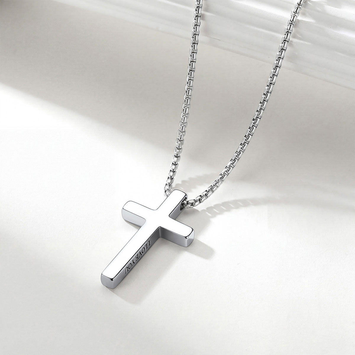 Silver cross necklace on a white background