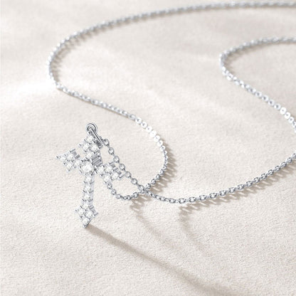 Silver cross necklace with a star-shaped pendant on a light beige background