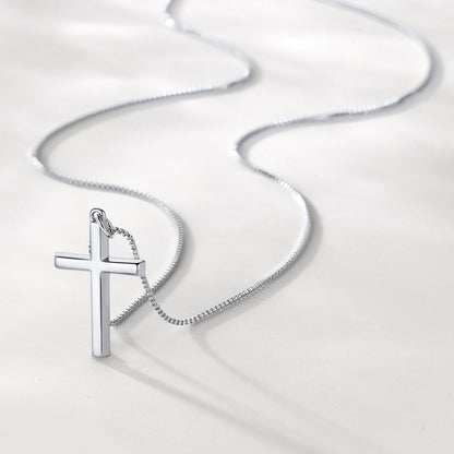 Silver cross pendant on a chain against a white background