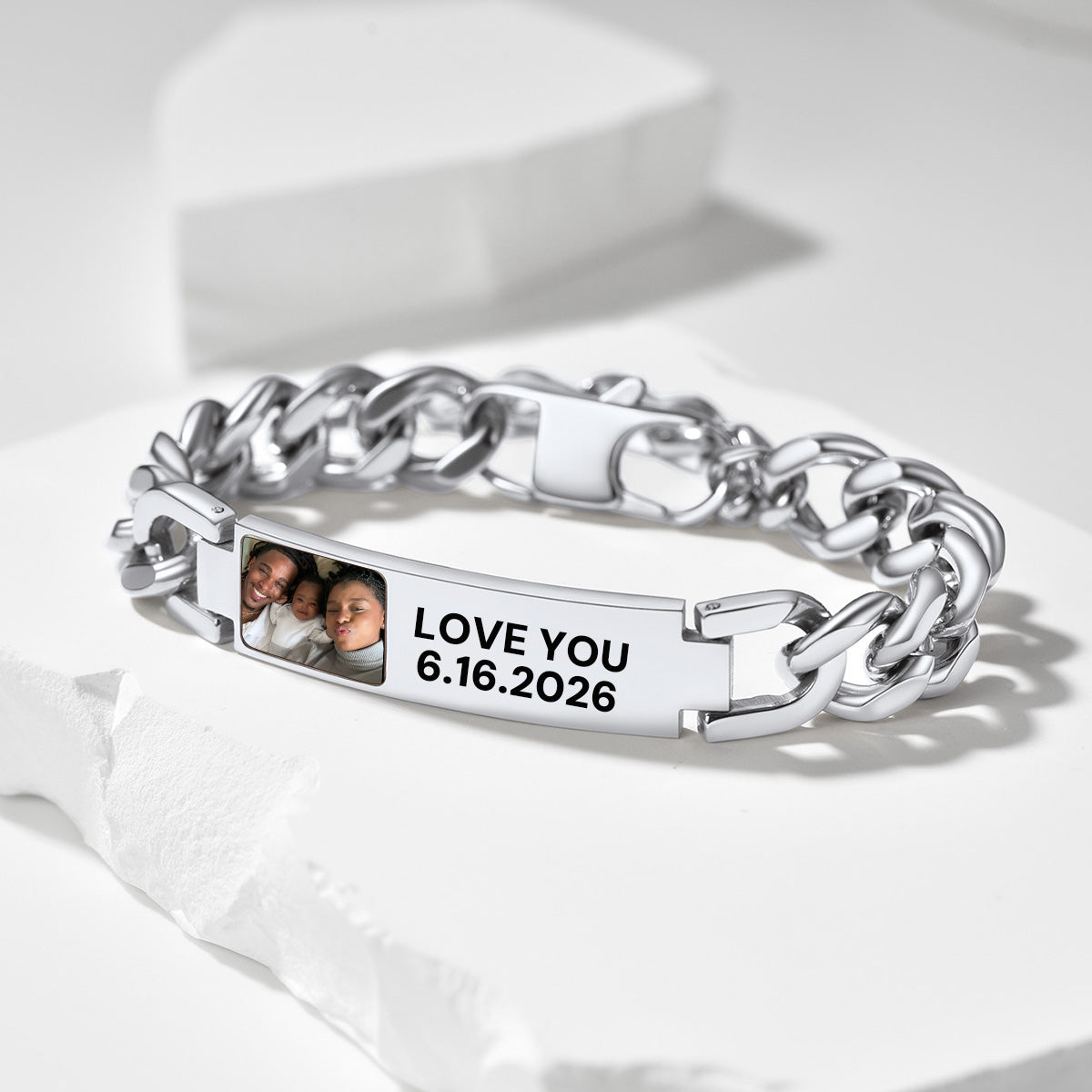 Silver cuban link bracelet with photo and text engraving on a white surface