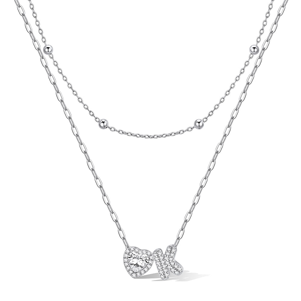 Silver cz bubble initial K necklace with a heart-shaped pendant on a white background