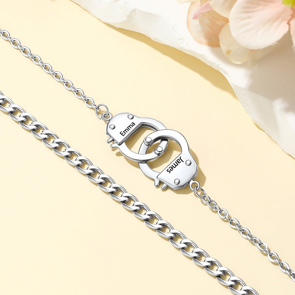 Silver handcuff-shaped ankle bracelet on a chain with 'Elsa' branding against a light background.