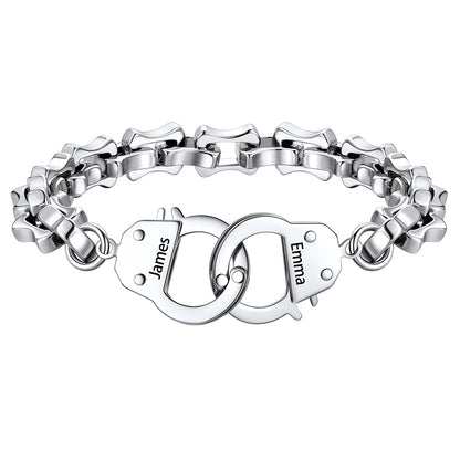 Silver handcuff bracelet with interlocking heart charms engraved with names on a white background