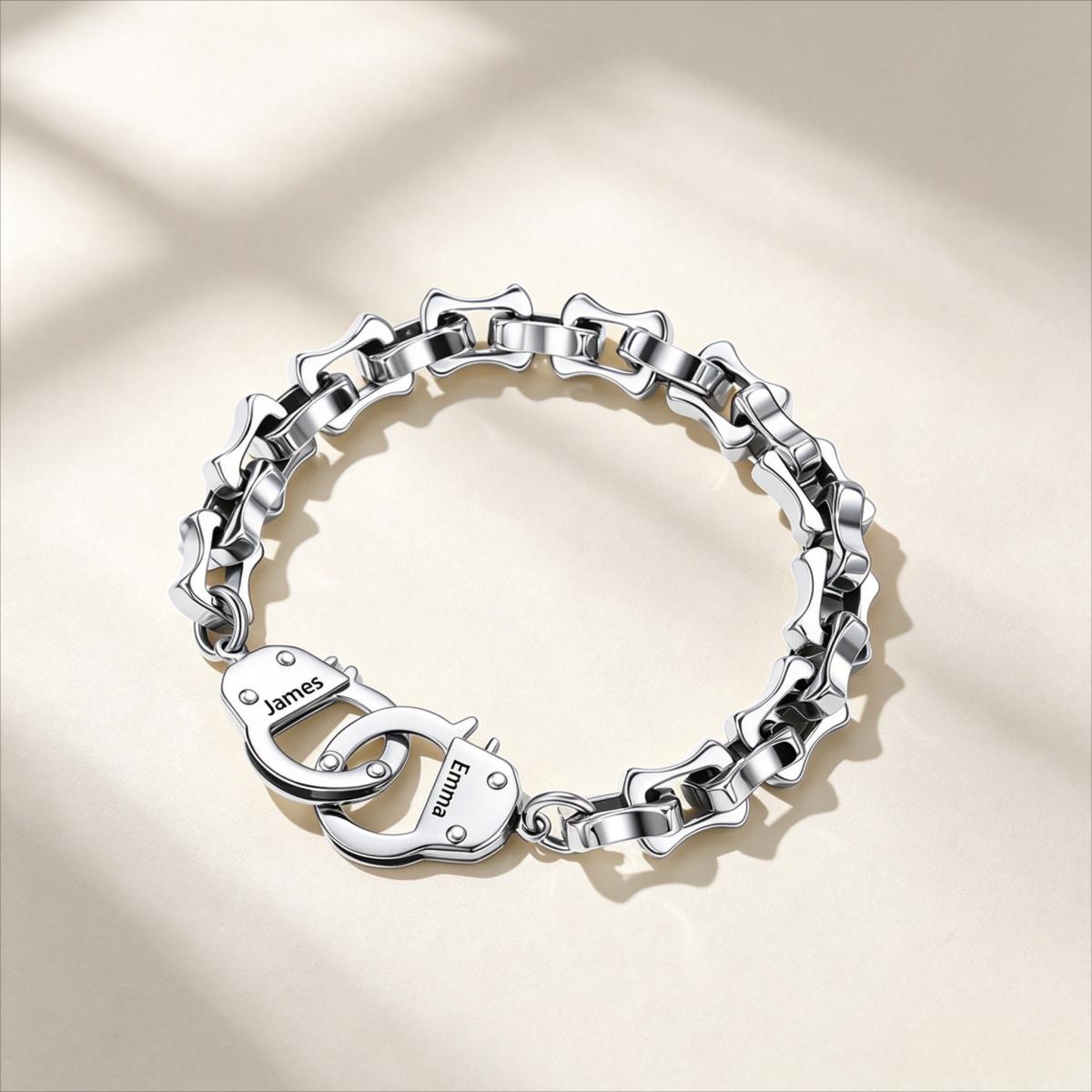Silver handcuff bracelet with interlocking heart charms on a beige background