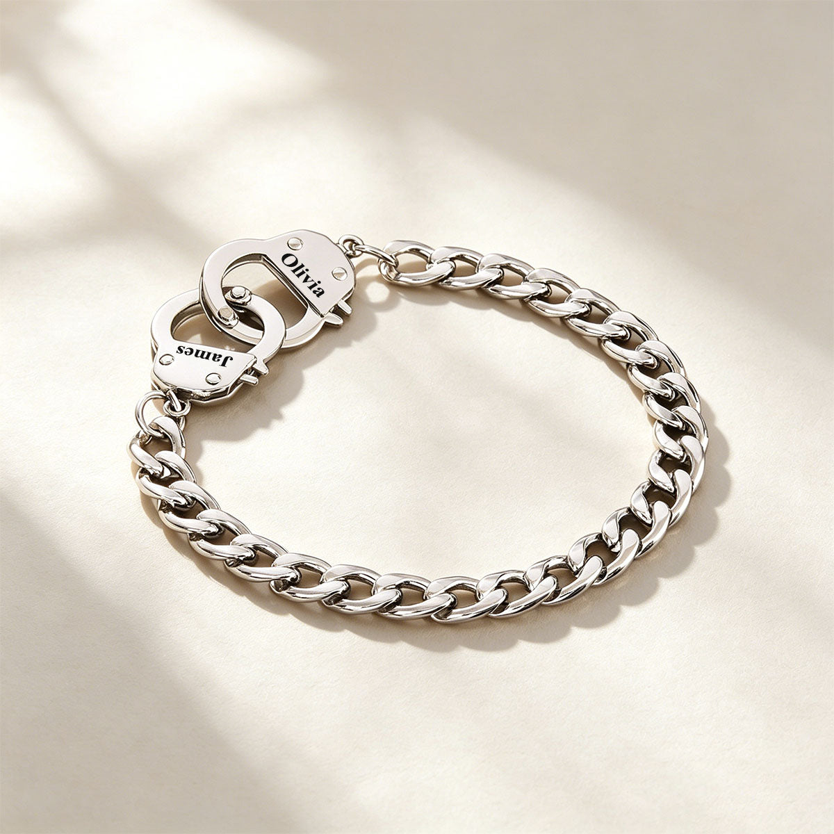 Silver handcuff chain bracelet with a clasp on a light background