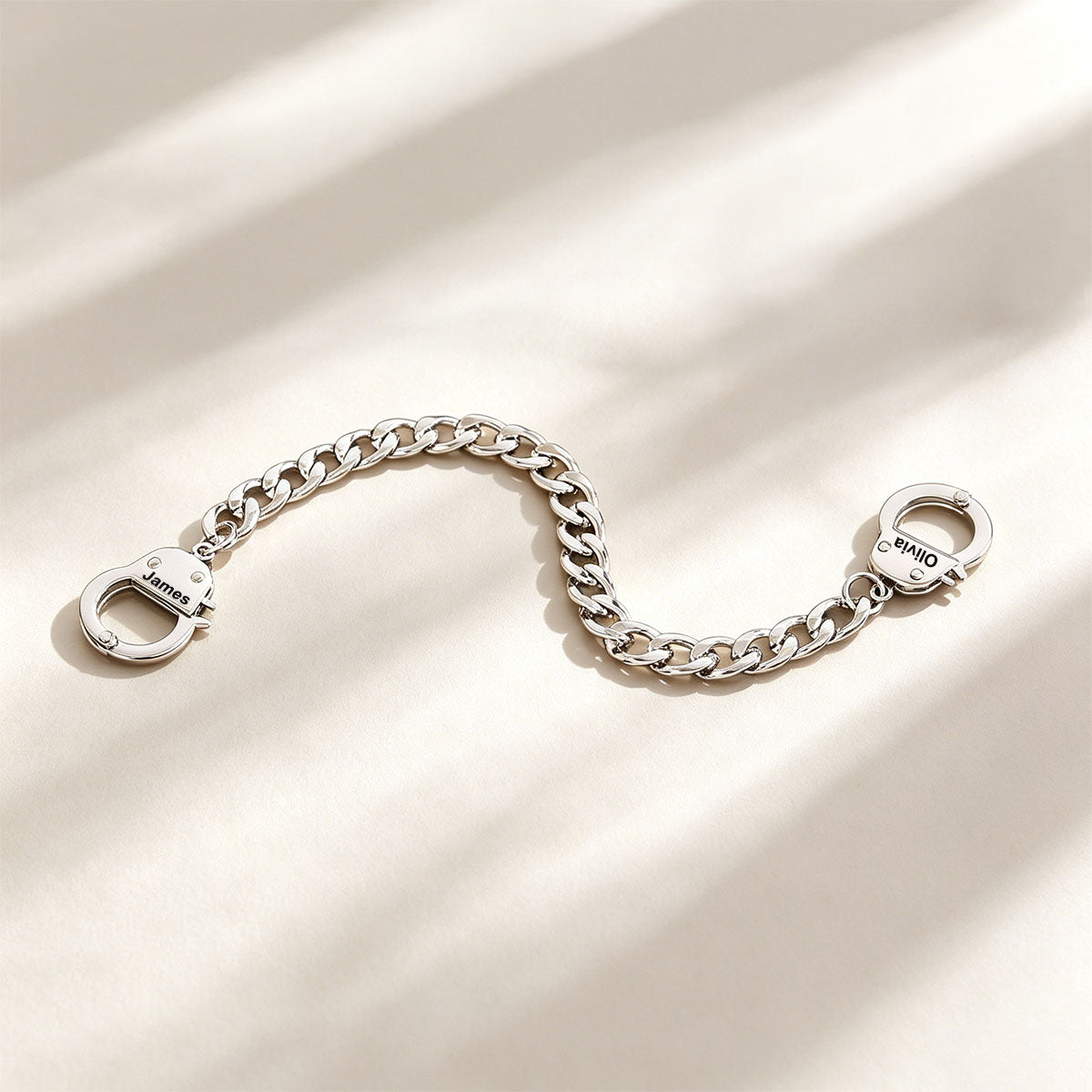 Silver handcuff chain bracelet with clasp on a beige background