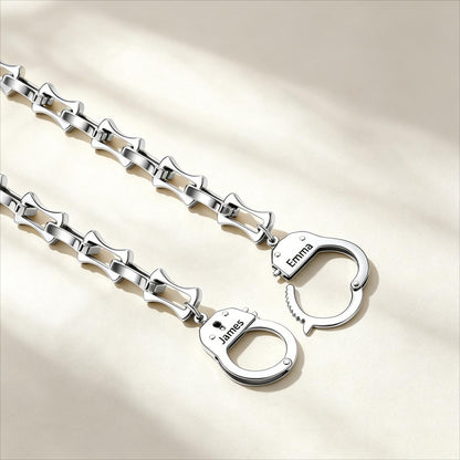 Silver handcuffs bamboo chain with engraved names on a beige background
