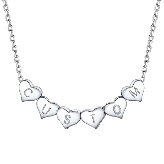 Silver heart initial necklace with heart-shaped charms spelling 'CUSTOM' on a white background