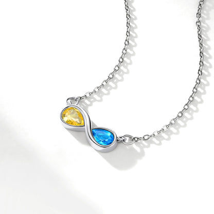 Silver infinity necklace with yellow and blue gemstones on a white background