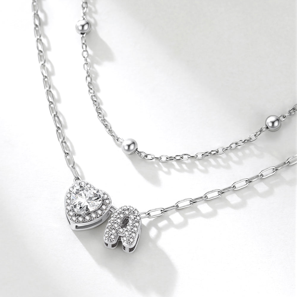 Silver initial necklace with heart and letter 'A' pendant on a white background