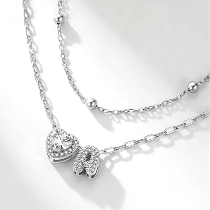 Silver initial necklace with heart and letter 'A' pendant on a white background