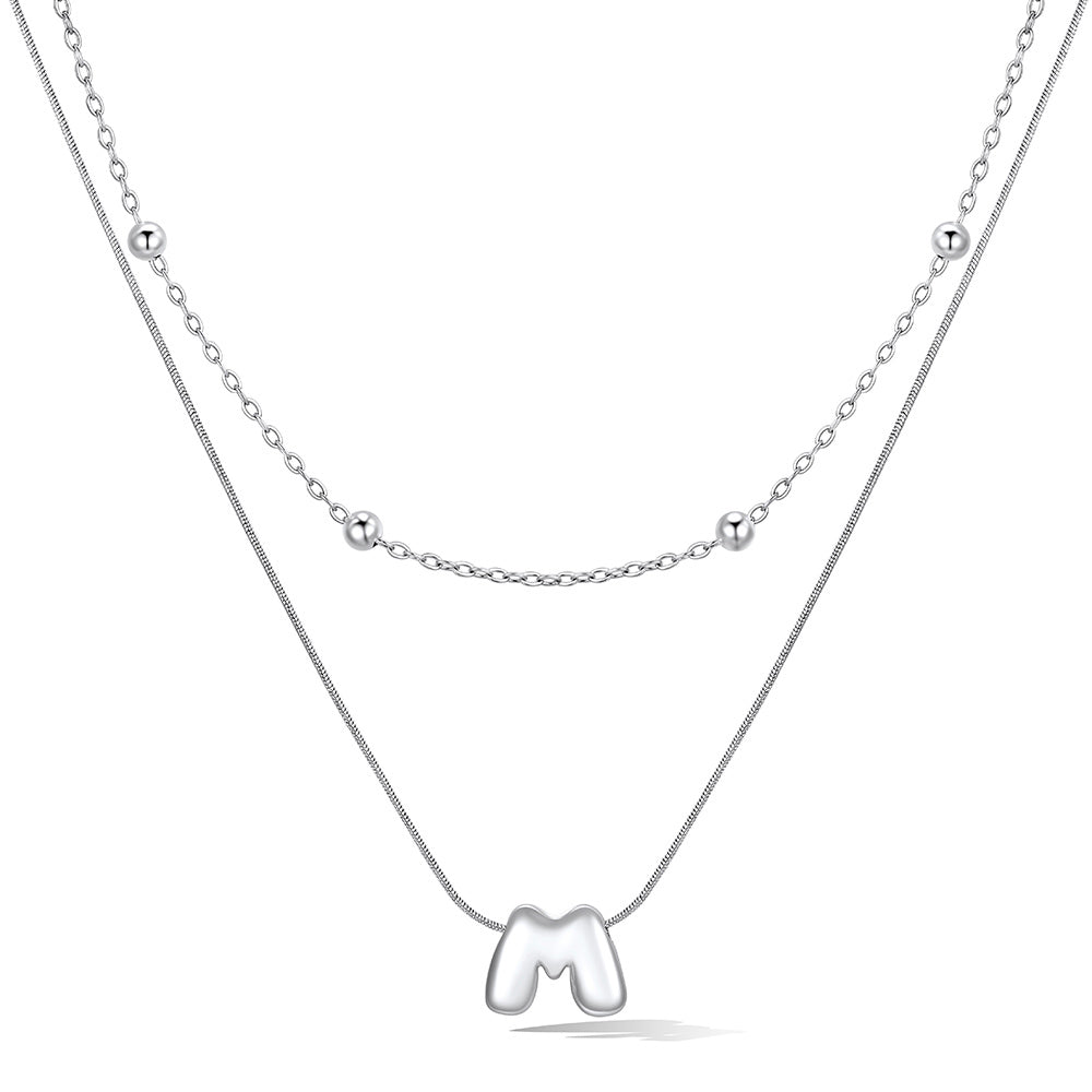 Silver layered initial M necklace, showing measurements and material details.