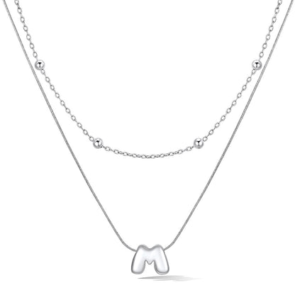 Silver layered initial M necklace, showing measurements and material details.