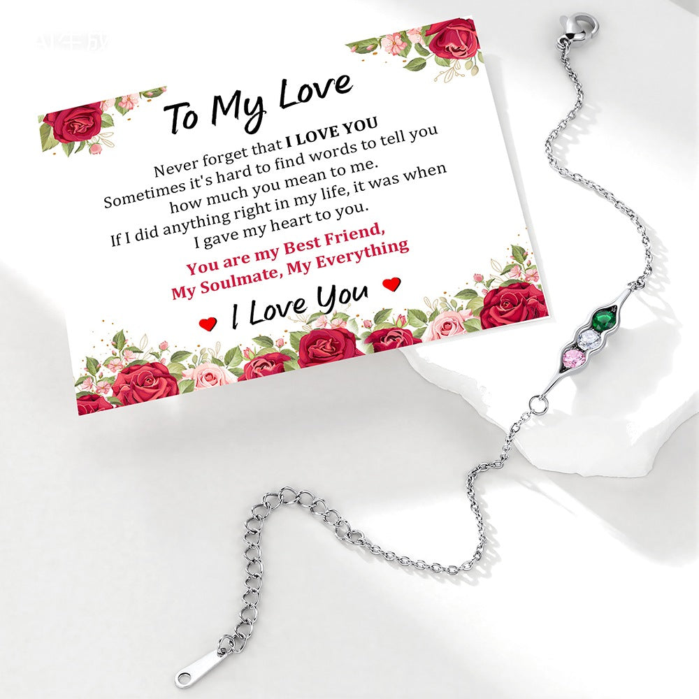 Silver pea in pot bracelet with gemstones on a card with floral design and romantic text.