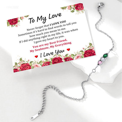 Silver pea in pot bracelet with gemstones on a card with floral design and romantic text.