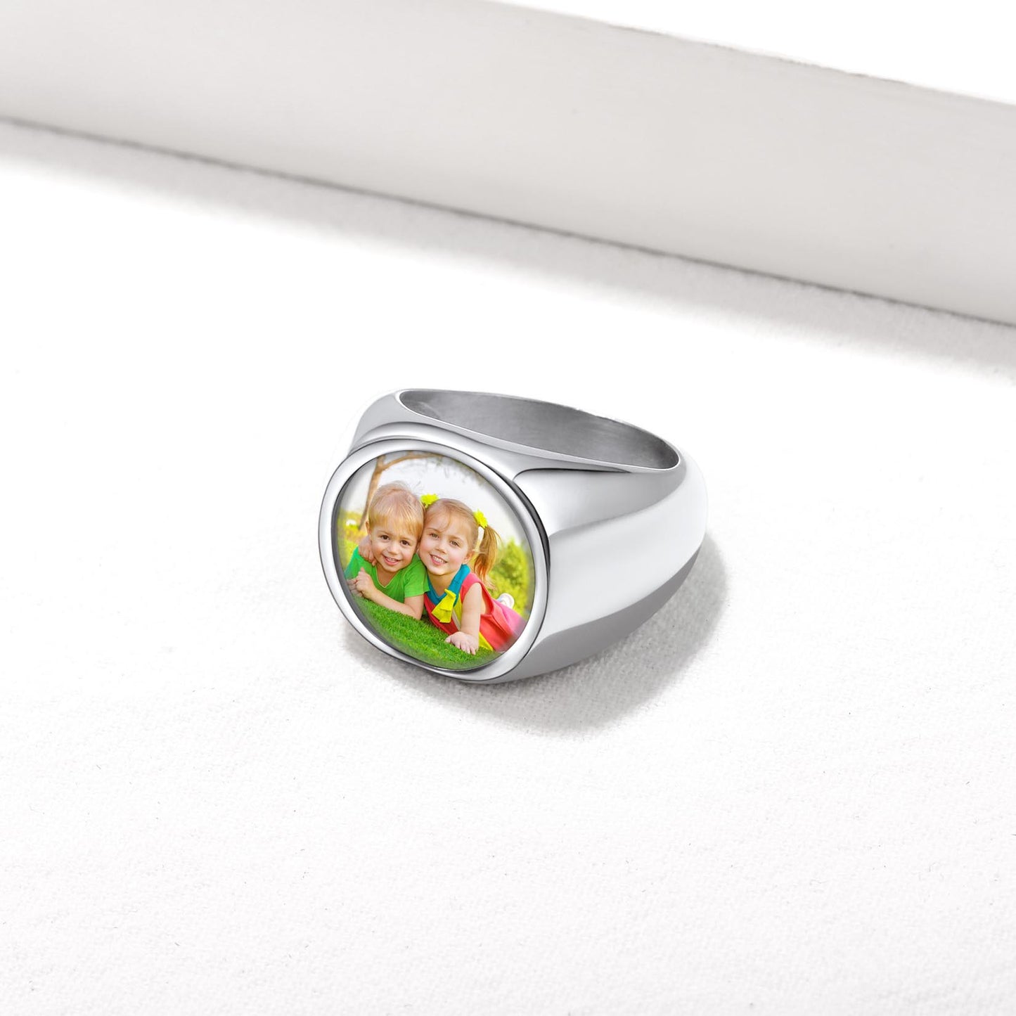 Silver personalized signet ring with a photo of two children on a white background