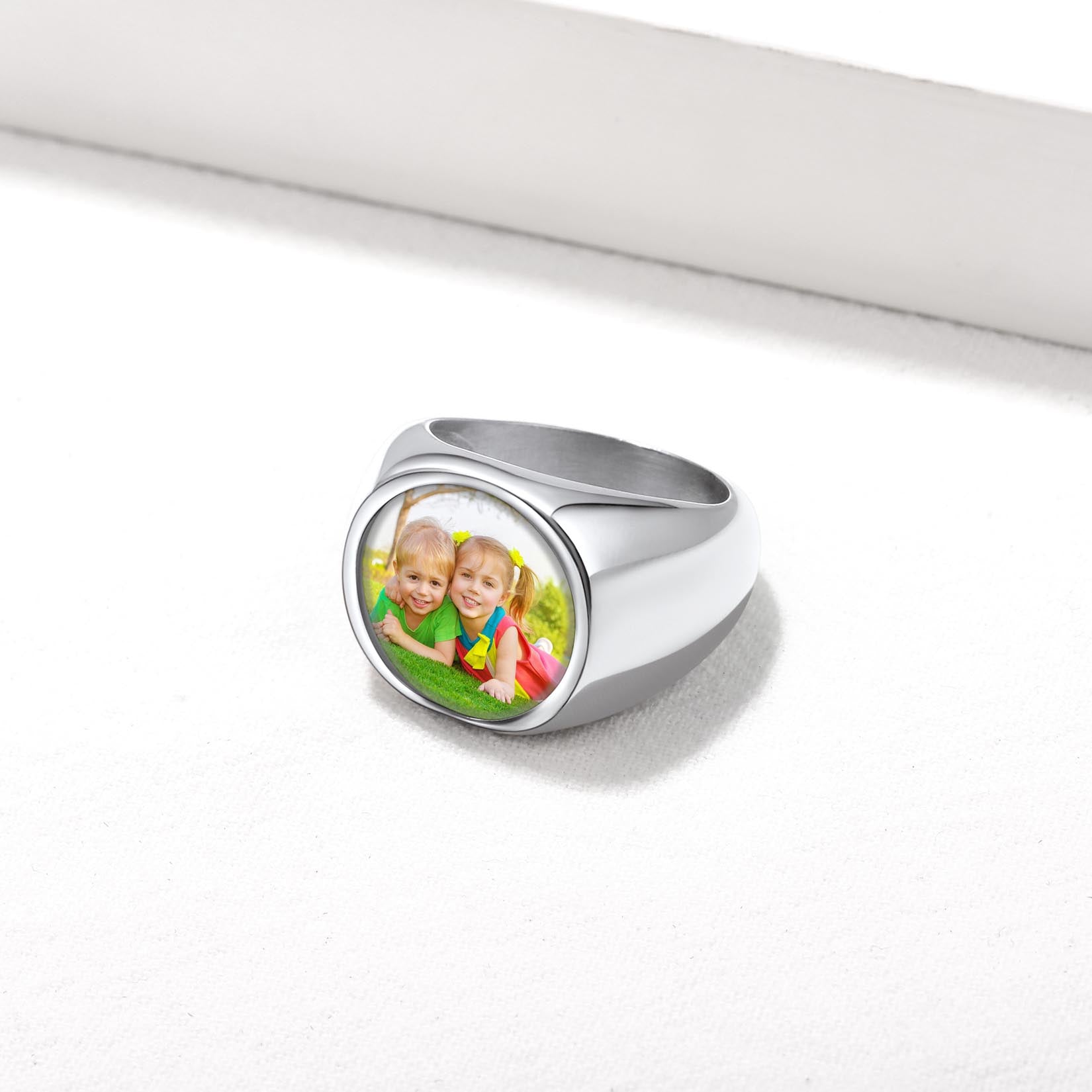 Silver personalized signet ring with a photo of two children on a white background