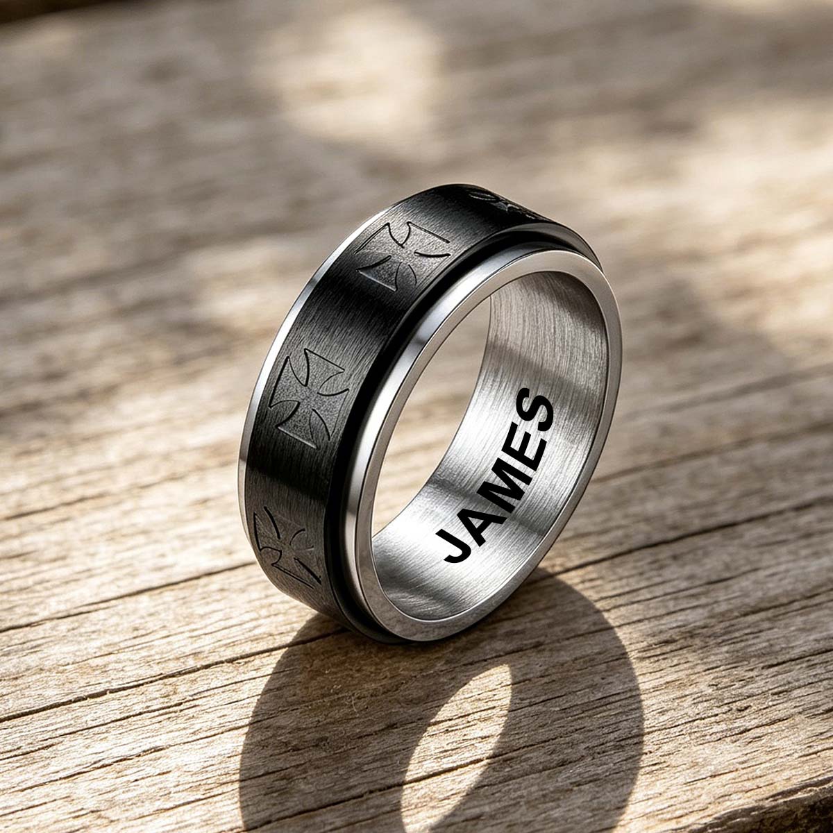 Silver ring with engraved name on a wooden surface
