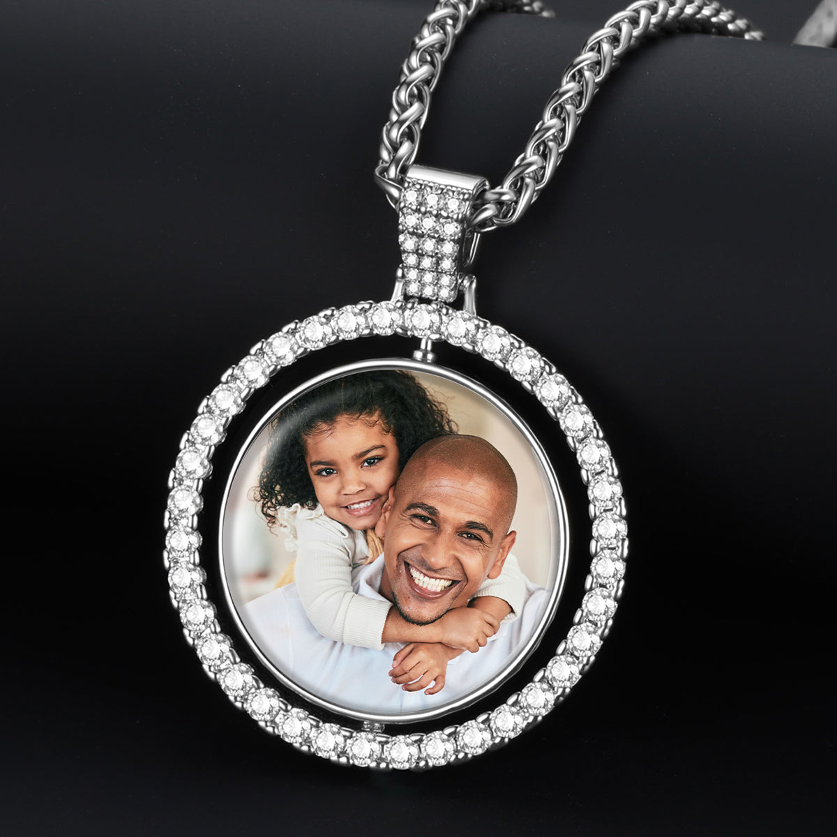Silver rotatable picutre necklace with a round pendant featuring a photo of a man and a child on a black background