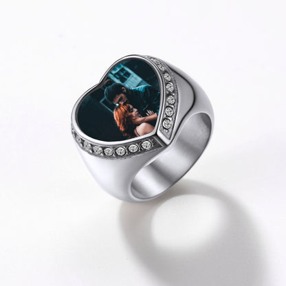 Silver signet ring with a heart-shaped photo insert on a white background
