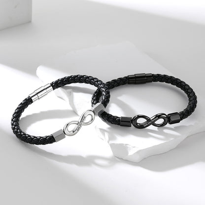 Two black braided leather infinity bracelets with infinity-shaped metal clasp details, displayed on a white surface with soft shadows.