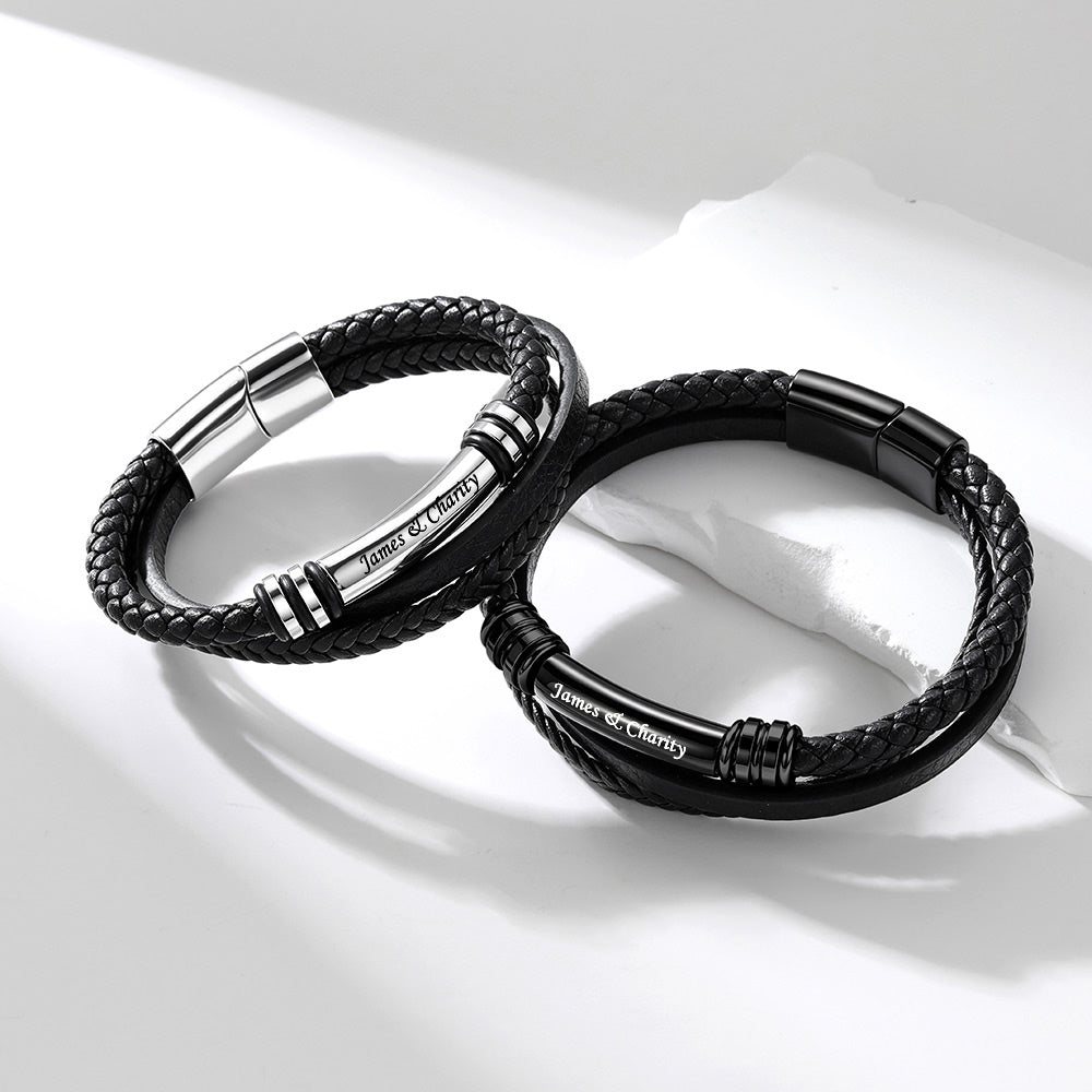 Two black braided rope engraved bracelets with polished silver metal accents and the engraved text 'Justice and Charity', displayed on a clean white background.