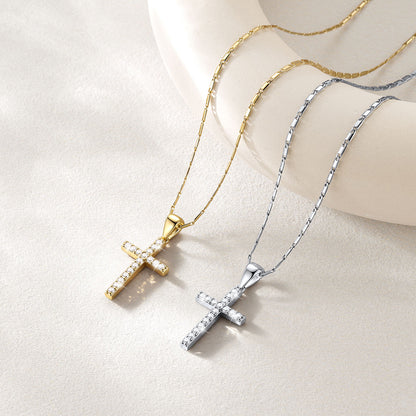 Two cross necklaces displayed on a cream-colored mannequin bust. One necklace is gold with a gold chain and a gold cross paved with small clear stones.