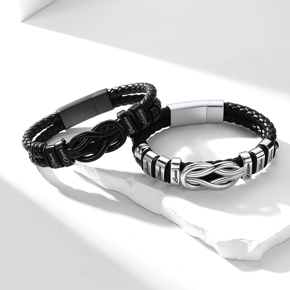 Two custom name black and silver bracelets on a white surface