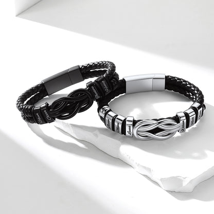 Two custom name black and silver bracelets on a white surface