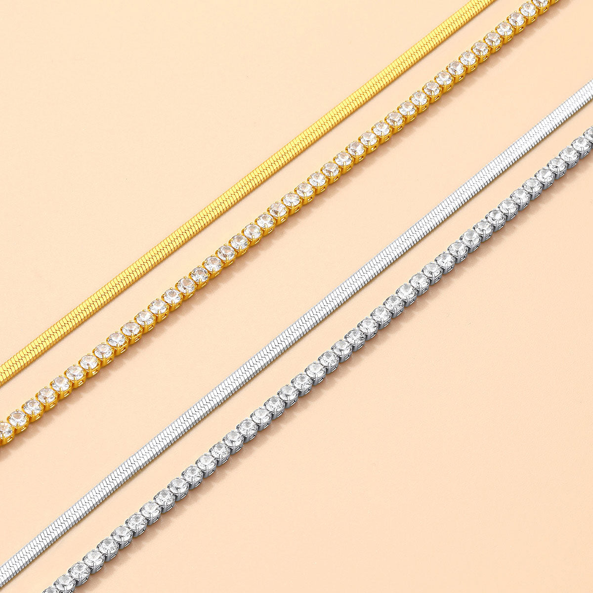 Two gold and two silver anklet set on a beige background