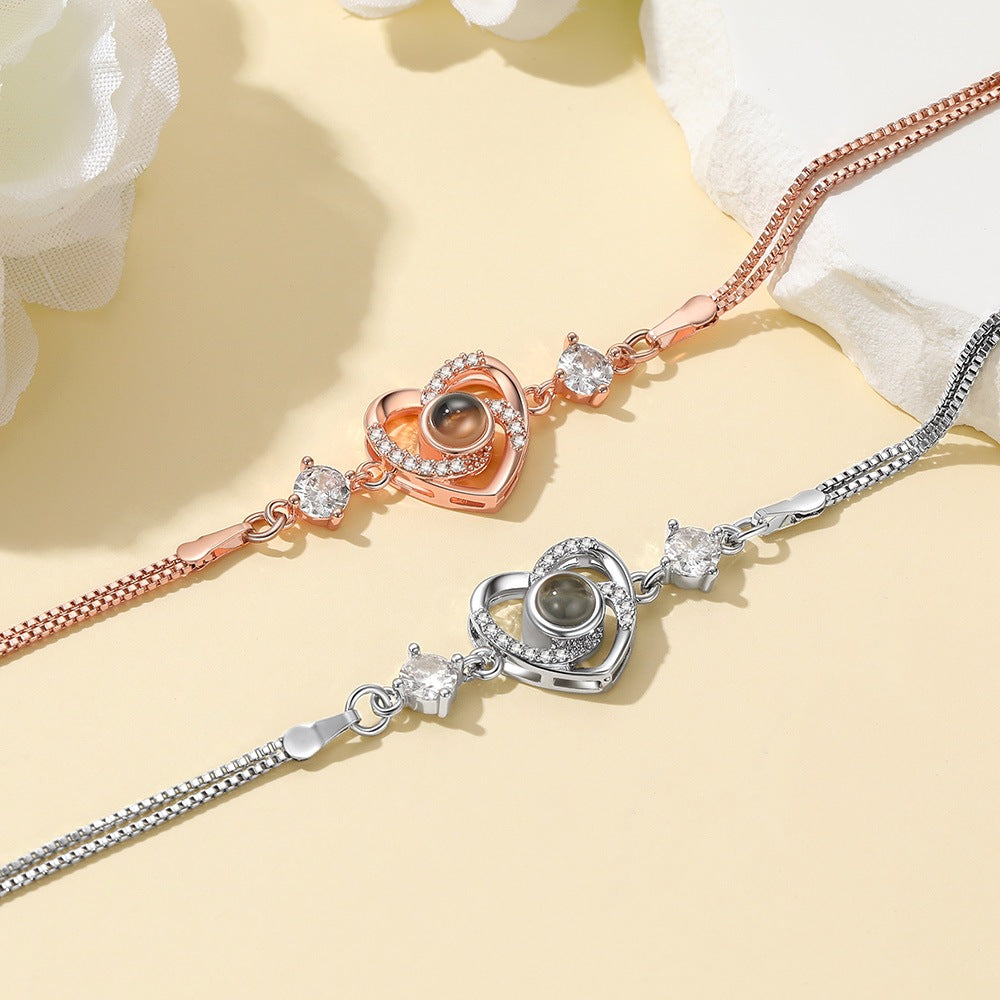 Two heart-shaped photo projection bracelet pieces on a light yellow background