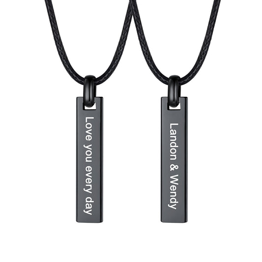 Two matching black rectangular engraved bar necklaces on black cords, shown against a plain white background. One pendant reads 'Love you every day' and the other reads 'Landon & Wendy'.