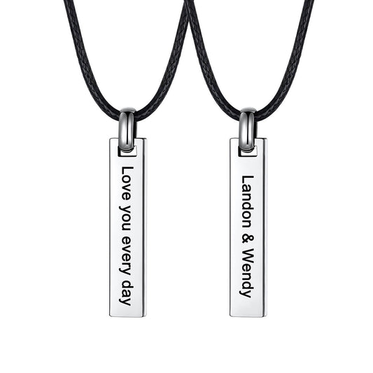 Two matching silver bar pendant necklaces on black cords, shown against a white background. One pendant is engraved with 'Love you every day' and the other with 'Landon & Wendy'.