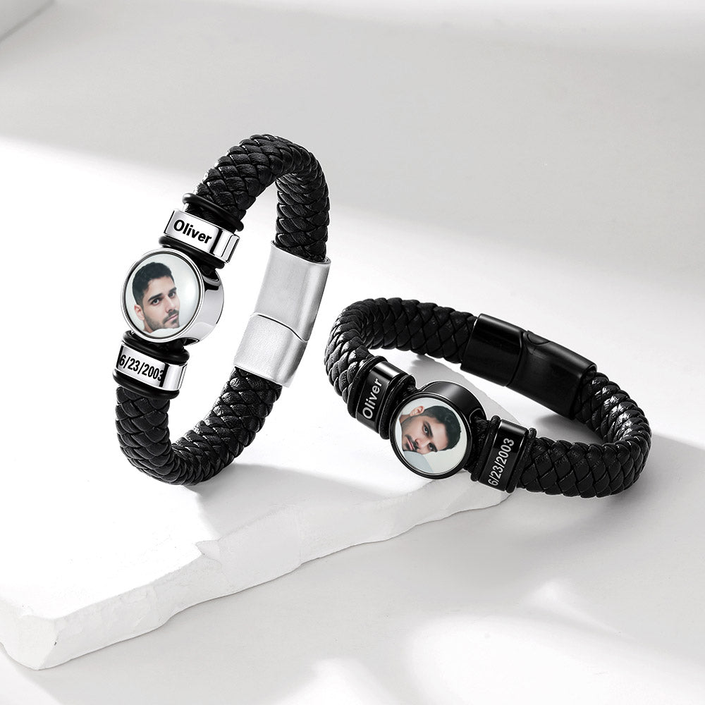Two personalized black braided leather bracelets with silver-toned metal accents and circular photo inserts, displayed on a clean white surface.