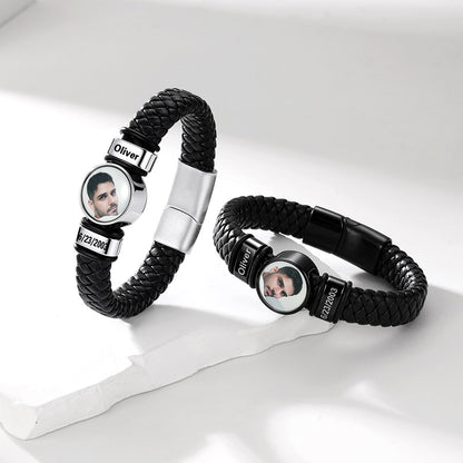 Two personalized black braided leather bracelets with silver-toned metal accents and circular photo inserts, displayed on a clean white surface.