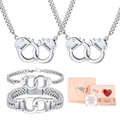 Two silver handcuff-shaped necklaces and two matching bracelets with engraved names (Kevin and Glanna, and Dalton and Amy), shown alongside a peach gift bag and a small heart-themed gift box on a white background.