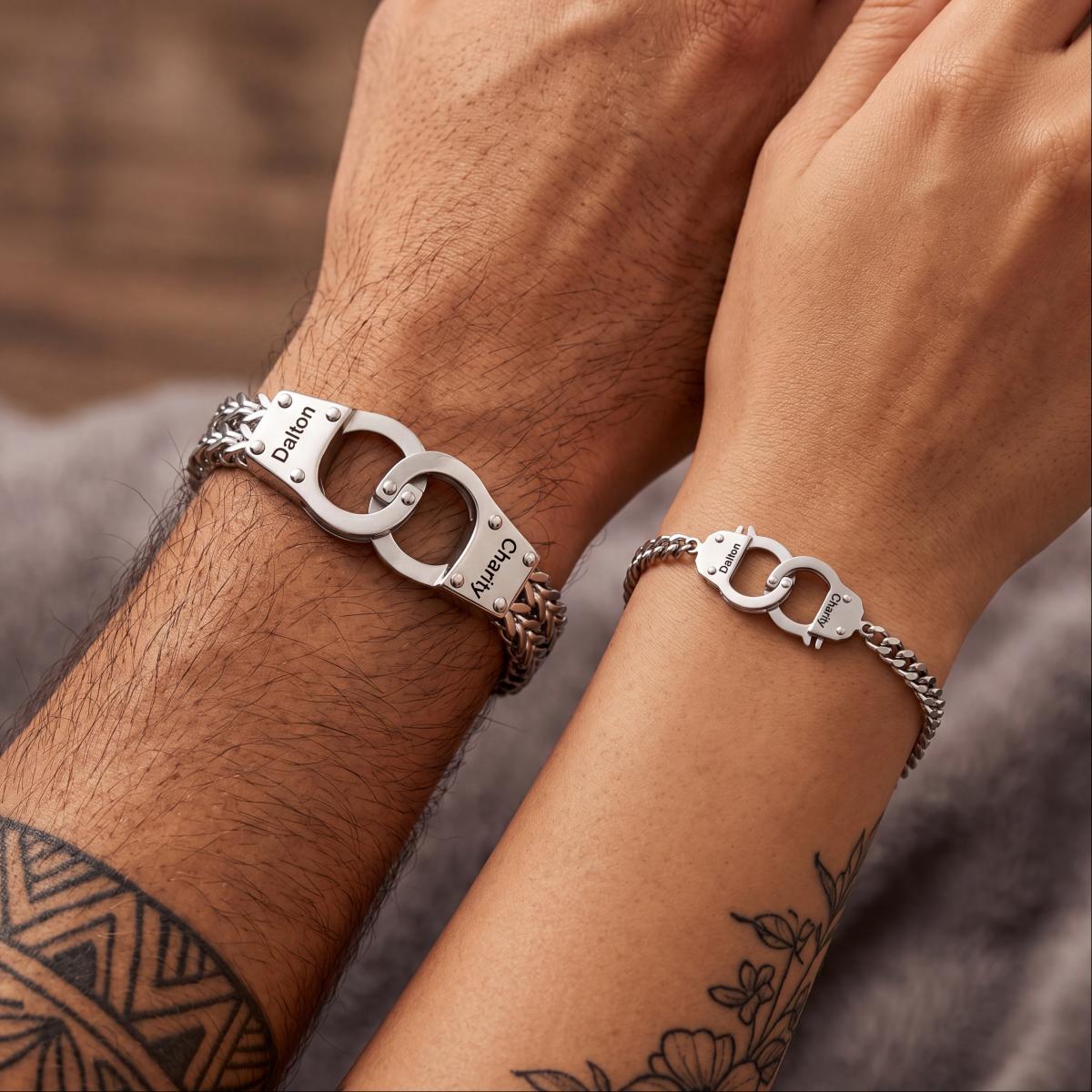 Two silver interlocking handcuff bracelets on matching wrists, one larger engraved with 'Damon' and 'Kung' and one smaller engraved with 'Leo' and 'Ning'.