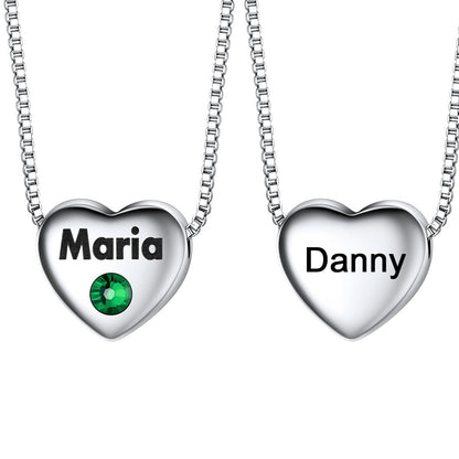 Two heart-shaped name pendants on silver chains with 'Maria' and 'Danny' engraved.
