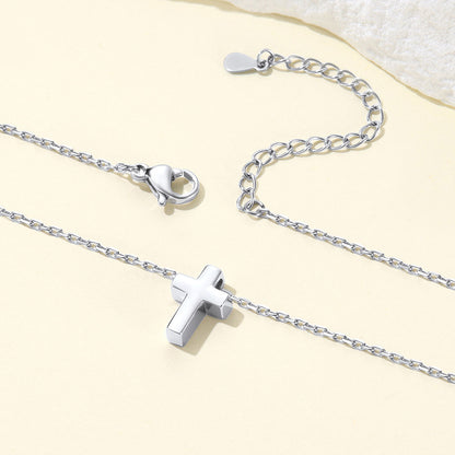 Silver cross necklace with a cross pendant on a light beige background