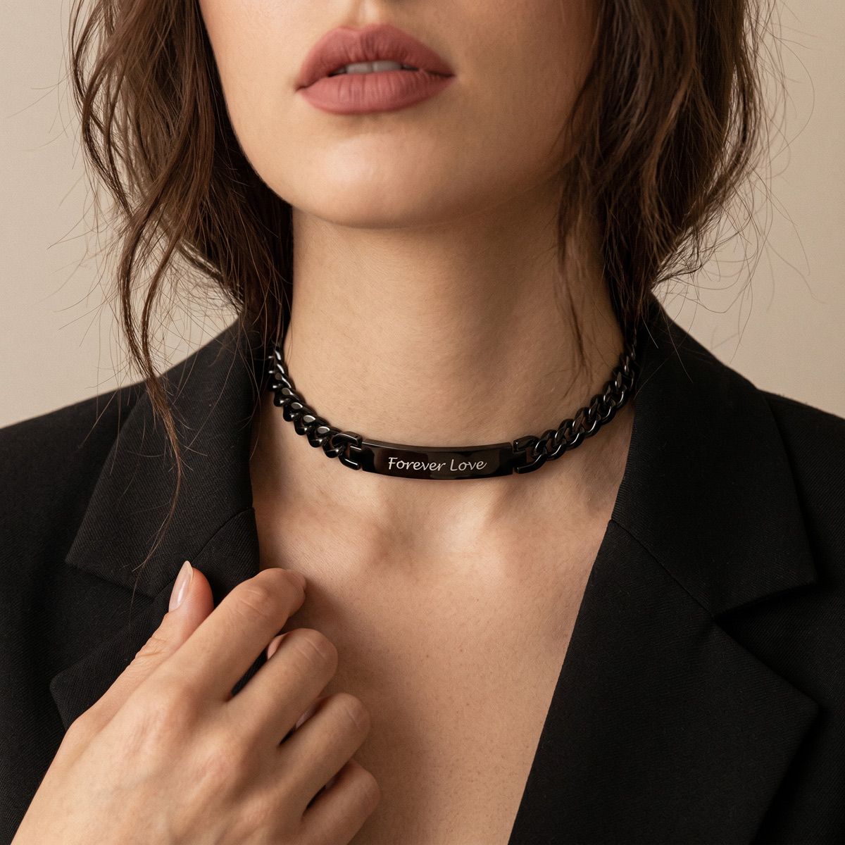Woman wearing a black cuban chain choker necklace with 'Forever Love' engraving on a neutral background