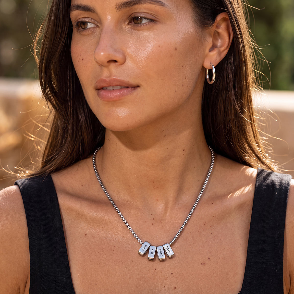 Woman wearing a multi namenecklace with pendant names outdoors