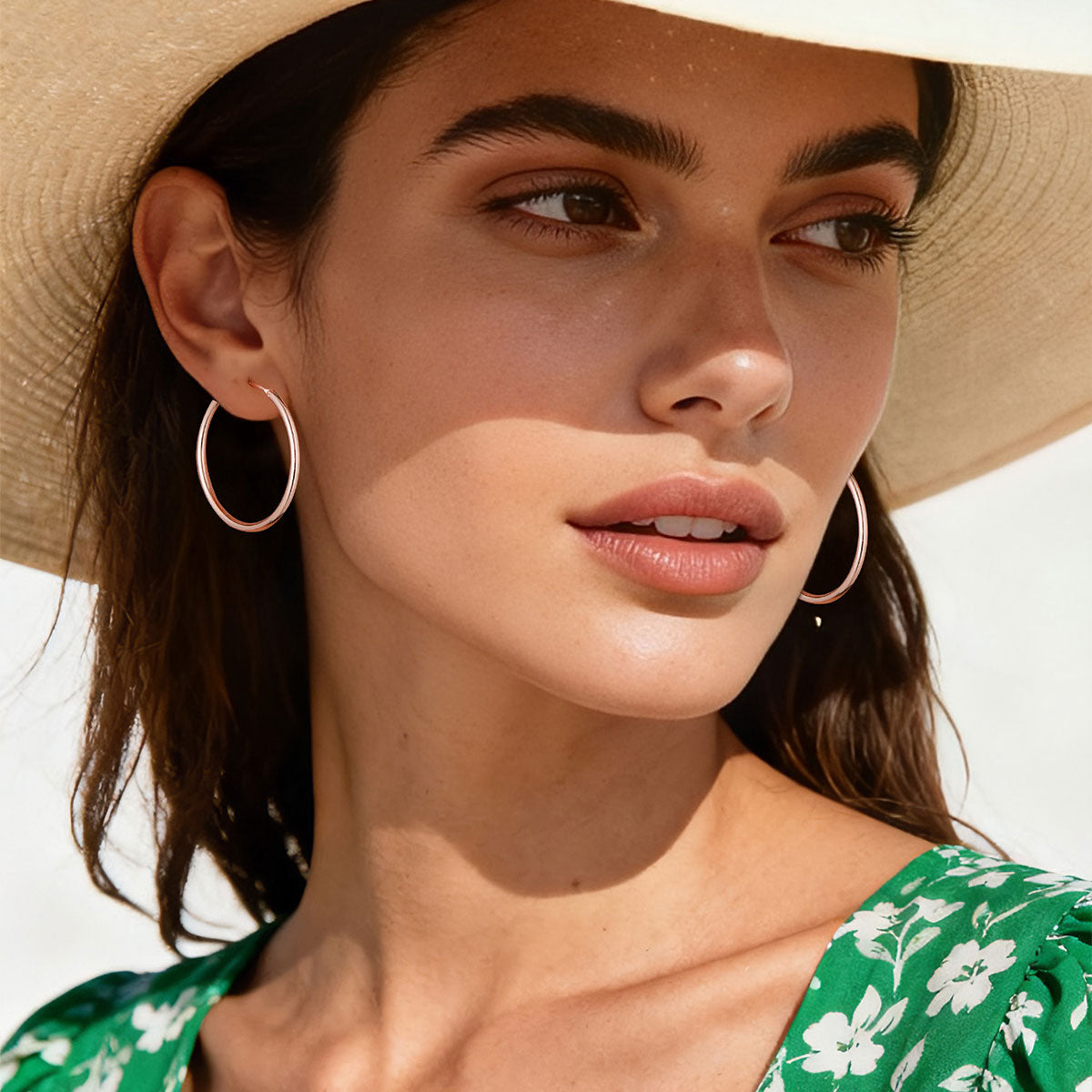 Woman wearing a straw hat and hoop earrings with a blurred background
